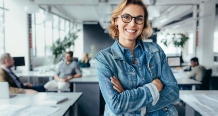 Happy female designer standing in office