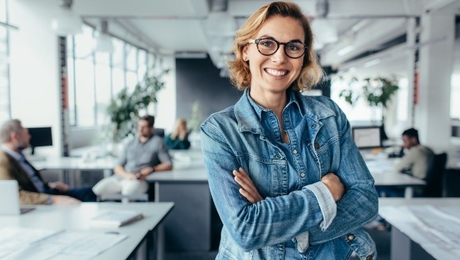 Happy female designer standing in office